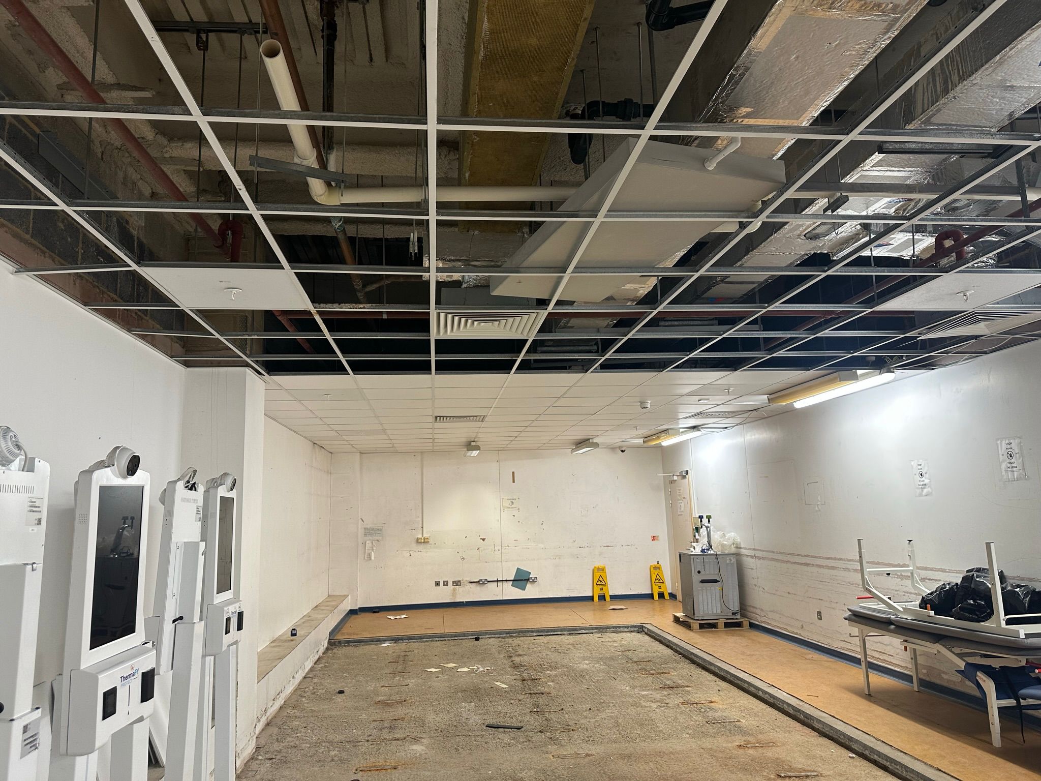 Healthcare facility interior during asbestos survey with ceiling grid exposed